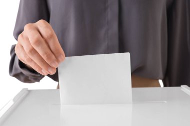 Beyaz arka planda oy sandığına oy veren kadın, yakın plan.