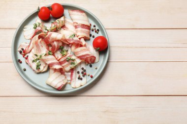 Çiğ domuz pastırması, baharat ve domates dilimleri, ahşap masa, üst manzara. Metin için boşluk