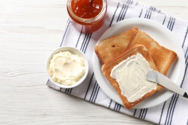 Lezzetli kızarmış ekmek, reçelli ve bıçaklı beyaz ahşap masa, düz uzanmış.