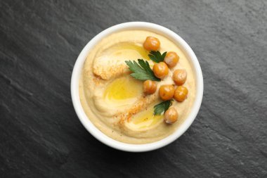 Zeytinyağlı enfes humus, bezelye ve maydanoz kasede gri desenli masa, üst manzara.