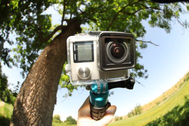 Modern aksiyon kamerası ve monopod açık hava kameralı adam, yakın plan. Fisheye lens etkisi