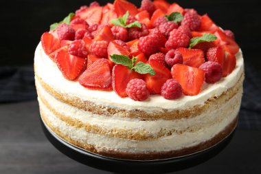 Taze böğürtlenli lezzetli sünger kek ve koyu gri masada nane şekeri.