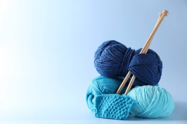 Farklı iplikler, örgü iğneleri ve hafif arkaplanda desen örnekleri. Metin için boşluk