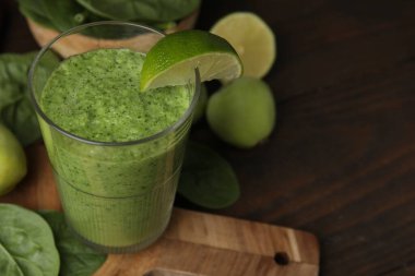 Limonlu, elmalı ve ahşap masadaki ıspanaklı tatlı yeşil smoothie, yakın plan. Metin için boşluk