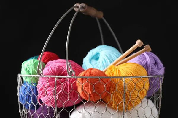 stock image Many soft skeins of yarn in metal basket on black background, closeup