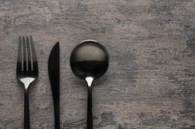 Gri masadaki şık çatal bıçak takımı, düz. Metin için boşluk