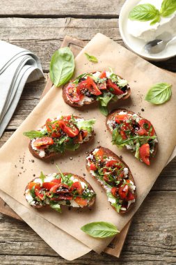 Lezzetli ricotta bruschetta domatesli, roka ve fesleğen ahşap masada, düz yatıyordu.