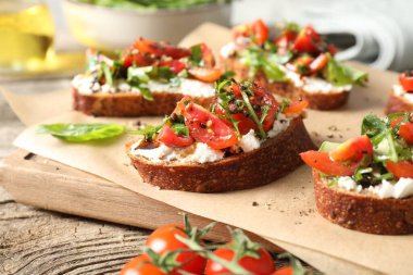Lezzetli ricotta bruschetta domates ve roka ile ahşap masa, yakın çekim
