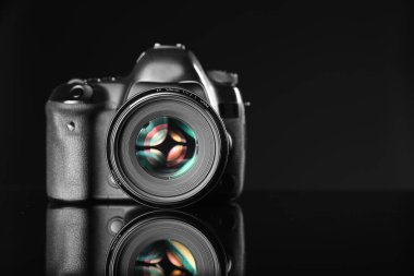 Siyah ayna yüzeyinde modern bir fotoğraf makinesi, metin için boşluk