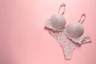 Pembe arka planda zarif dantelli kadın iç çamaşırı, üst manzara. Metin için boşluk