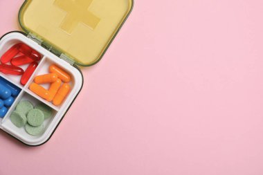 Pembe arka planda, organizatörde farklı haplar var. Metin için boşluk