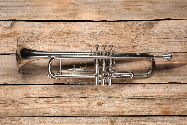 stock image One trumpet on wooden table, top view