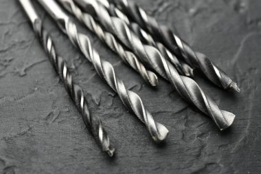 Gri masada çok sayıda matkap ucu var, yakın plan.