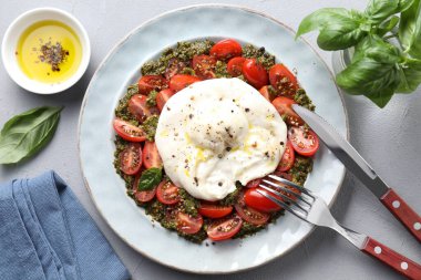 Açık gri masada servis edilen taze lezzetli burrata salatası.