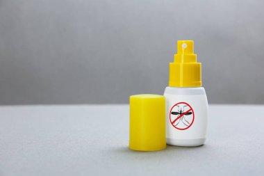 Gri arka planda sivrisinek spreyi, mesaj için boşluk. Böcek kovucu