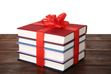 Beyaz arka plana karşı ahşap masada kurdeleli kitap yığını