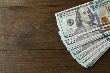 Ahşap masa üzerinde bir sürü dolar banknot, üst manzara. Metin için boşluk
