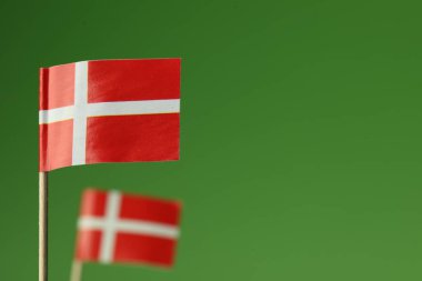 Yeşil arka planda Danimarka 'nın küçük kağıt bayrakları, seçici odaklanma. Metin için boşluk