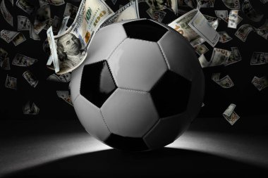 Siyah arka planda para altında futbol topu yağmuru