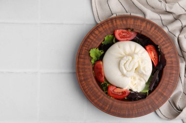 Beyaz fayanslı masada kasede nefis burrata salatası, üst manzara. Metin için boşluk