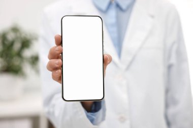 Doktor, hastanede boş ekranlı akıllı telefon gösteriyor, seçici odaklanma