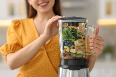 Mutfakta blender ile nefis smoothie yapan kadın, yakın plan.