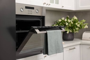 Mutfakta havluyla elektrikli fırını aç. Yemek pişirme aygıtı