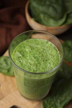 Lezzetli yeşil smoothie cam ve ıspanak masada, yakın plan.