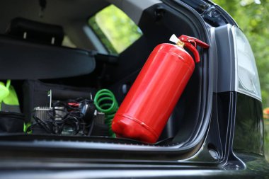 Bagajda kırmızı yangın söndürücü var. Araba güvenliği ekipmanı