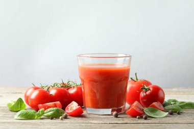 Bardaktaki lezzetli domates suyu taze sebzeler ve ahşap masada baharatlar.