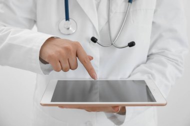 Beyaz arkaplanda tableti olan doktor, yakın plan görünümü
