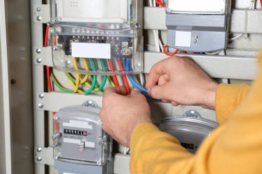 Elektrik sayacından bağlantı kablolarını kontrol eden adam, yakın görüntü