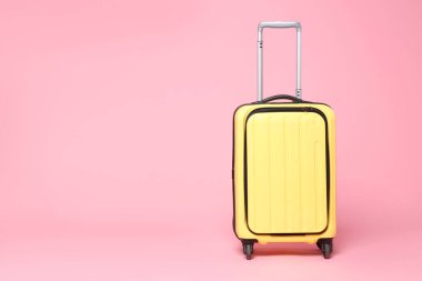 Pembe arka planda yeni bir sarı bavul, mesaj için boşluk