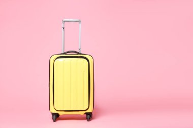 Pembe arka planda yeni bir sarı bavul, mesaj için boşluk