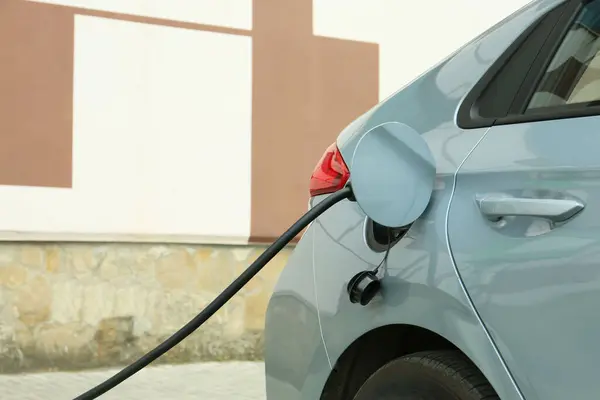 Stock image Modern electric car charging from station outdoors