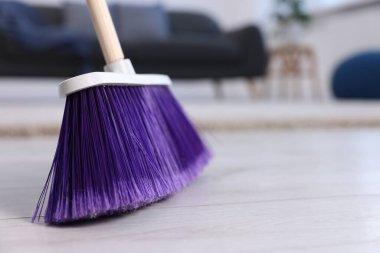 İçerideki ahşap zeminde süpürge temizleme, yakın çekim. Metin için boşluk