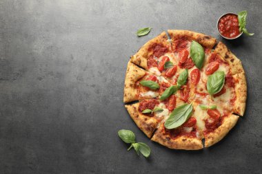 Lezzetli Margherita pizza, fesleğen ve domates sosu, gri masa, üst manzara. Metin için boşluk