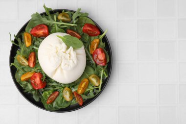 Beyaz fayanslı masada nefis burrata salatası, üst manzara. Metin için boşluk
