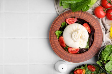Beyaz fayanslı masa üzerinde bulaşık takımında nefis burrata salataları, düz yatak. Metin için boşluk