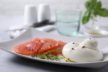 Nefis burrata peyniri, greyfurt ve baharatlar açık gri masada, yakın plan.