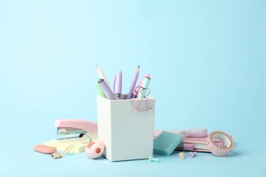 Açık mavi arkaplanda zımba ve diğer kırtasiye malzemeleri