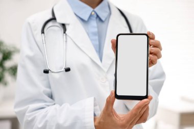 Doktor, hastanede boş ekranlı akıllı telefon gösteriyor, seçici odaklanma
