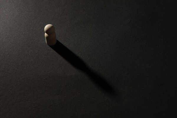 Концепция одиночества. Только человеческая фигура на черном фоне, вид сверху. Пространство для текста