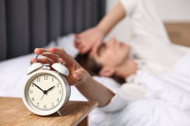 Kadın öğle yemeği saatinde yatak odasındaki çalar saati kapatıyor, seçici odaklanma