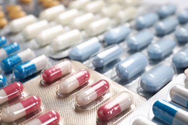 Arka planda su toplayan antibiyotik hapları, yakın plan.