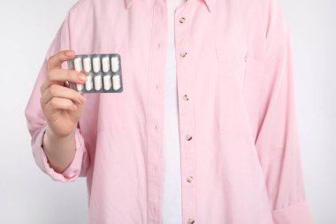 Arka planda antibiyotik haplı su toplayan kadın, yakın plan.