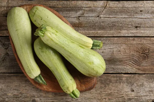 Ahşap masada çiğ yeşil kabaklar, üst manzara. Metin için boşluk