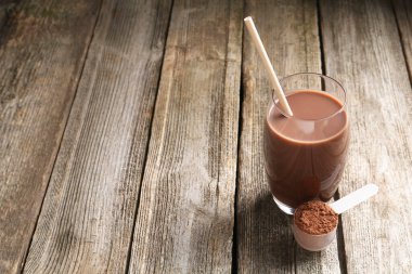 Lezzetli protein karışımı, cam ve toz dolu tahta masa, metin için yer.