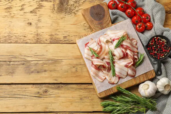 Çiğ domuz pastırması, baharat ve domates dilimleri, ahşap masa, düz yatak. Metin için boşluk
