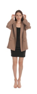 Süslü kahverengi ceketli ve beyaz arka planda siyah elbiseli güzel bir kadın.